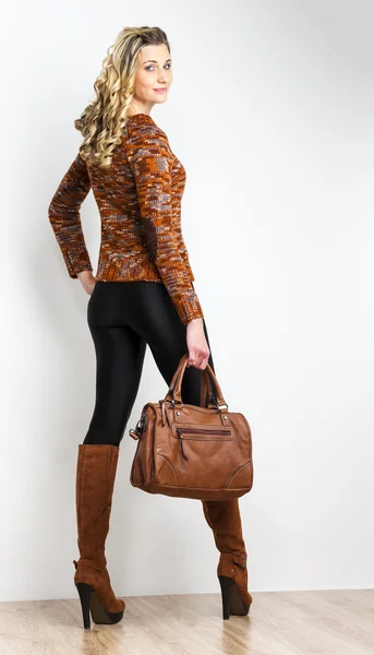 Mujer de pie con botas marrones de moda con un bolso — Foto de Stock