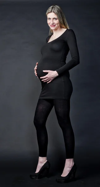 Pregnant woman wearing black clothes and pumps — Stock Photo, Image