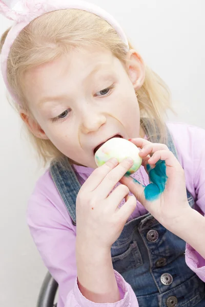 Portrait of little girl eating Easter egg — Stock Photo, Image