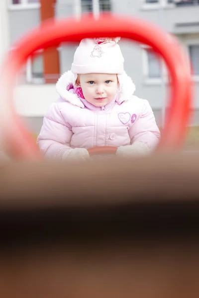 Маленькая девочка сидит на качелях — стоковое фото