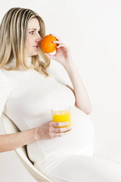 Portrait of pregnant woman with a glass of orange juice and an o — Stock Photo, Image