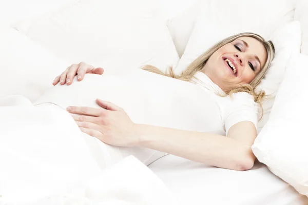Gravid kvinna vilar i sängen — Stockfoto