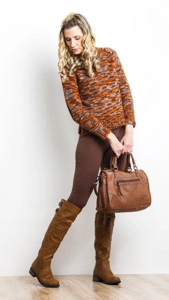 Standing woman wearing brown clothes and boots with a handbag — Stock Photo, Image