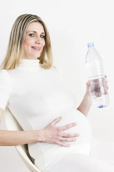 Portret kobiety w ciąży z butelką wody — Zdjęcie stockowe