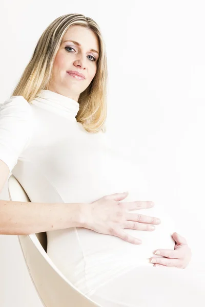 Beyaz elbise giyen oturma hamile kadın portresi — Stok fotoğraf