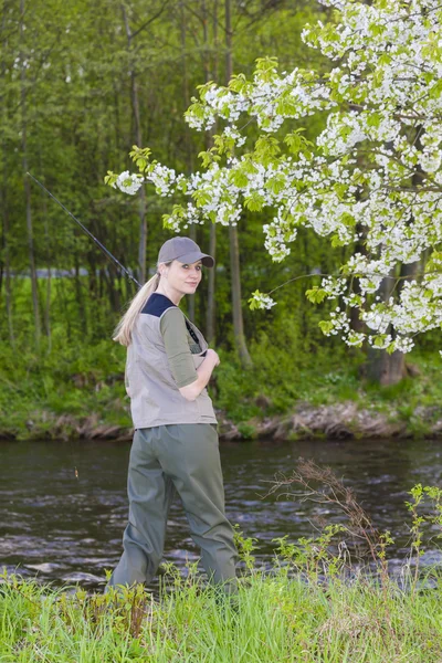 Vrouw vissen door de rivier in het voorjaar van — Stockfoto