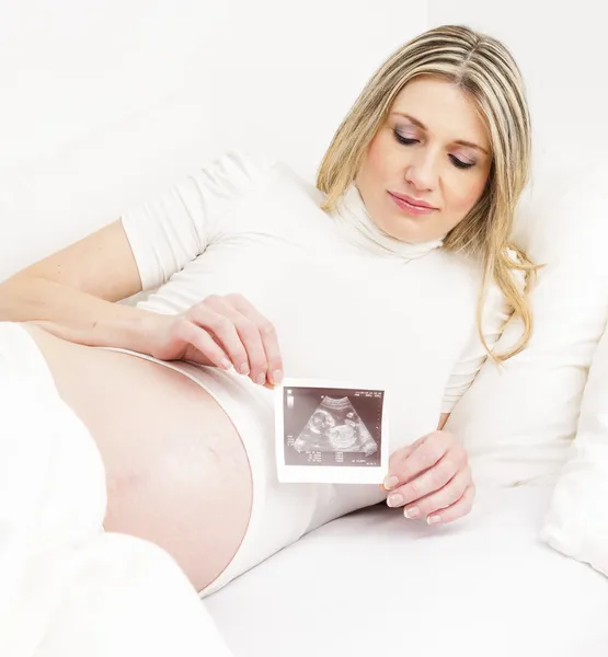 Gravid kvinna vilar i sängen — Stockfoto