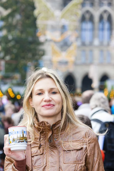 Mujer bebiendo vino caliente en el mercado de Navidad — Foto de Stock