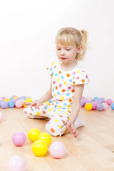 Little girl playing with balls Stock Image