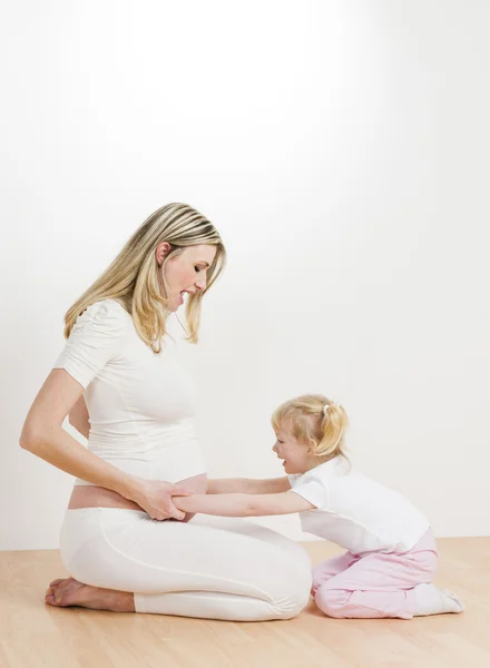 Meisje met haar zwangere moeder — Stockfoto