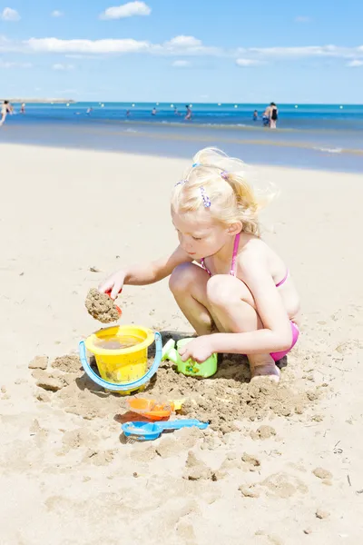 Klein meisje spelen op het strand op zee — Stockfoto