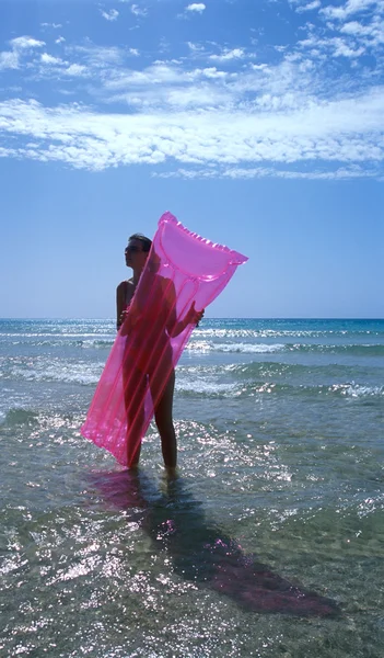Женщина с надувным матрасом — стоковое фото