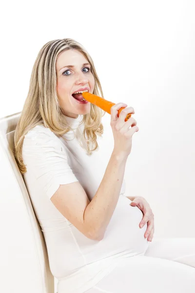 Mulher grávida comendo cenoura — Fotografia de Stock