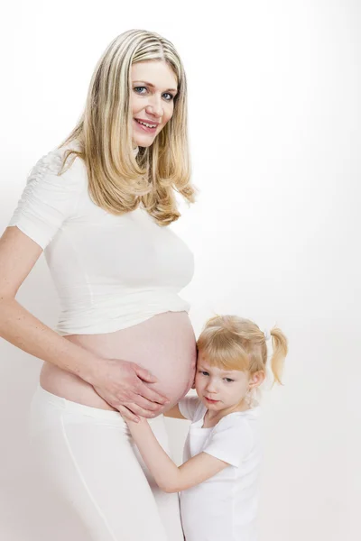 她怀孕的母亲的小女孩 — 图库照片