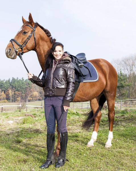 Equestrian with her horse on meadow — Stock Photo, Image