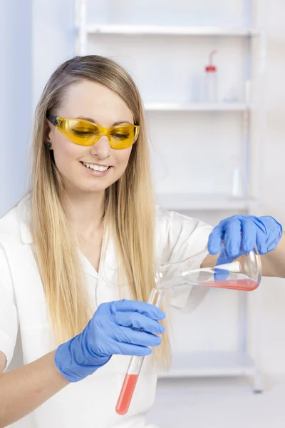 Ung kvinna gör experiment i laboratorium — Stockfoto
