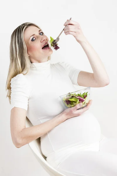 Mulher grávida comendo salada de legumes — Fotografia de Stock