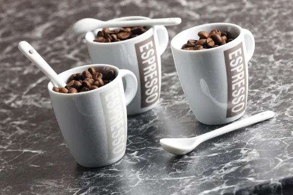 Coffee cups full of coffee beans — Stock Photo, Image