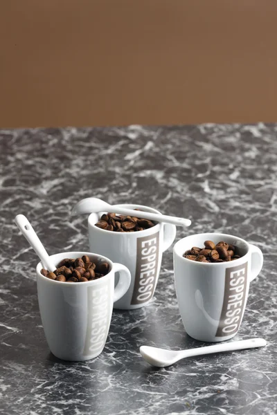 Xícaras de café cheias de grãos de café — Fotografia de Stock