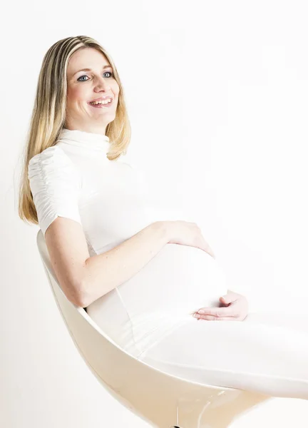 Porträtt av sammanträdet gravid kvinna klädd i vita kläder — Stockfoto