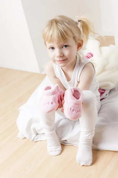 Kleines Mädchen mit Kleidung und Schuhen für ein Baby — Stockfoto