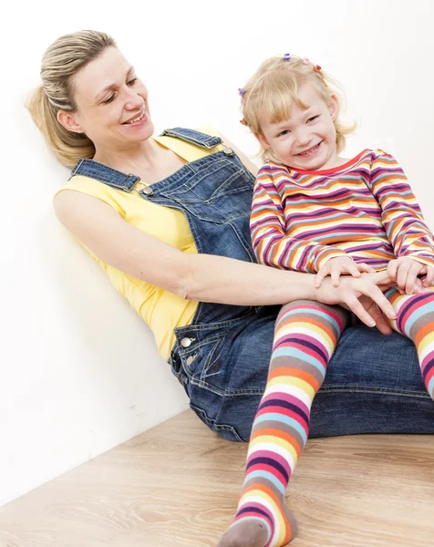 Little girl with her pregnant mother sitting on floor — Stock Photo, Image