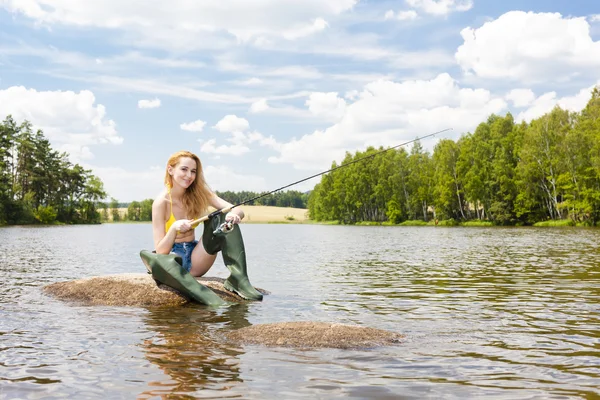 Mladá žena ryby v rybníku v létě — Stock fotografie