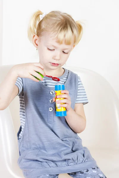 Kleines Mädchen spielt mit einem Blasenmacher — Stockfoto