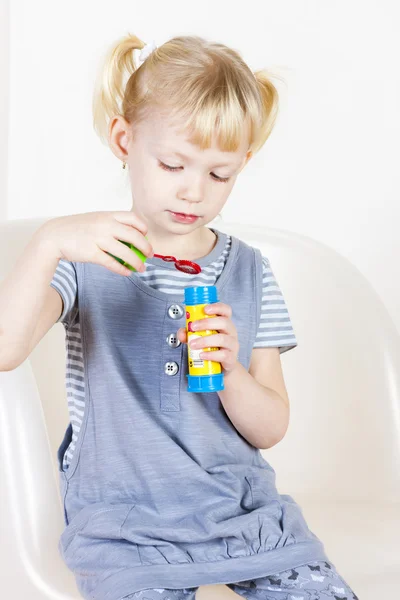 Niña jugando con un fabricante de burbujas — Foto de Stock