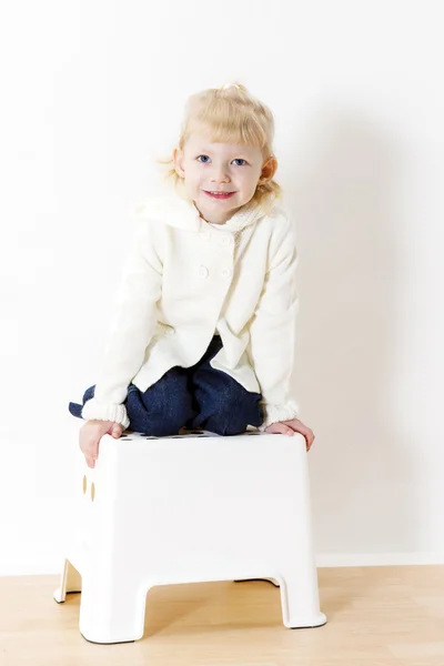 Arrodillada niña usando suéter blanco —  Fotos de Stock