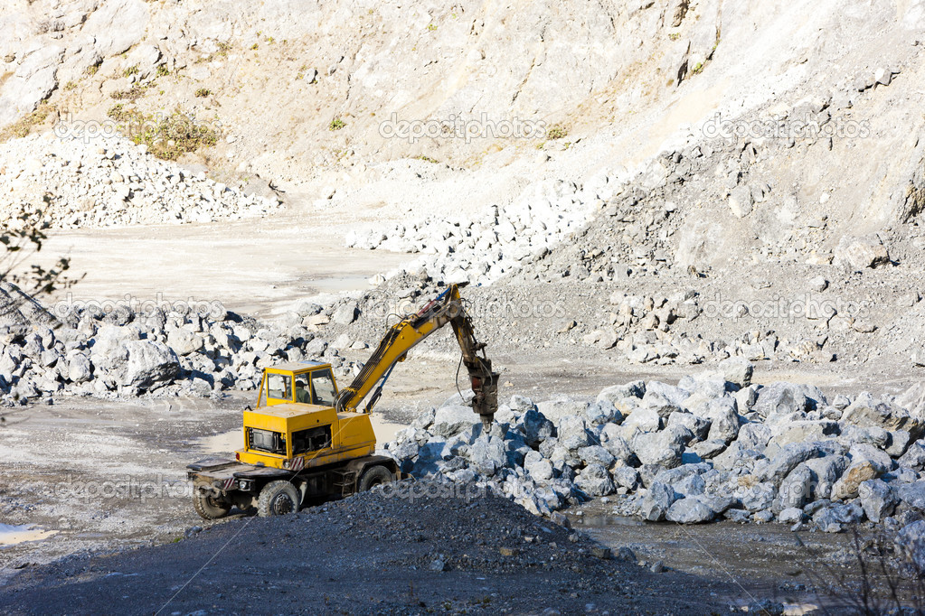 excavator loading rocks at quarry
