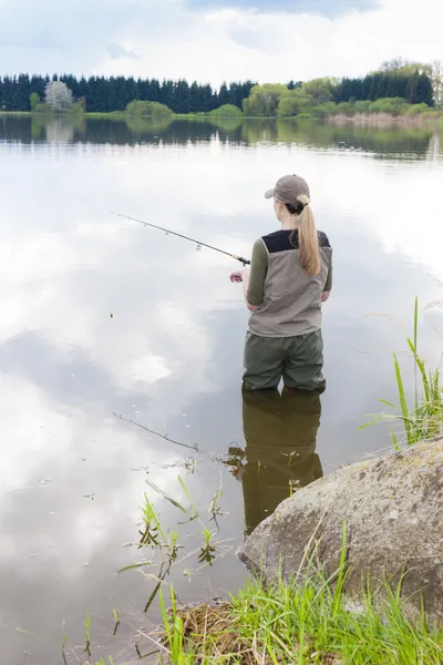 Mulher pesca na lagoa na primavera — Fotografia de Stock