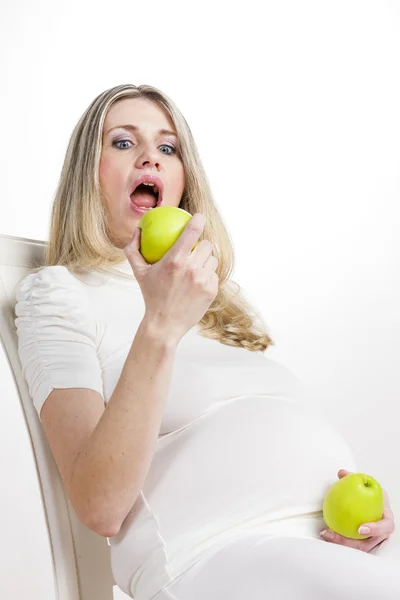 Gravid kvinna äta grönt äpple — Stockfoto