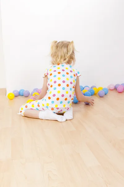 Klein meisje spelen met ballen — Stockfoto