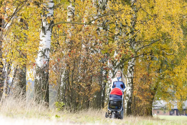 Kvinna med barnvagn på promenad — Stockfoto