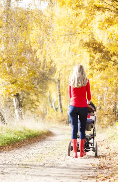 Vrouw met een kinderwagen op een wandeling — Stockfoto