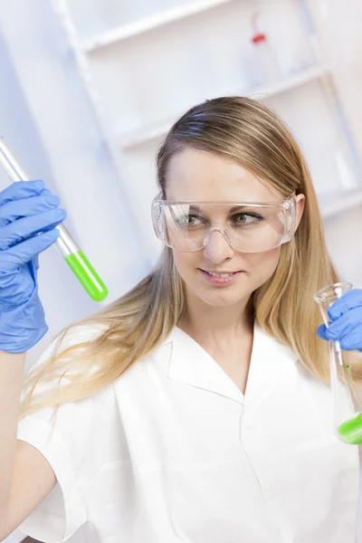 Молодая женщина проводит эксперименты в лаборатории — стоковое фото