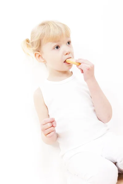 Kleines Mädchen isst Buscuit — Stockfoto