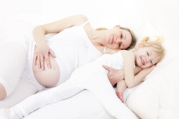 Meisje met haar zwangere moeder — Stockfoto