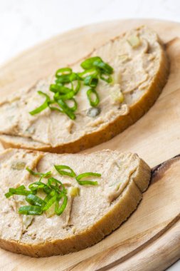 Çıtırtılar taze soğanla ekmeğe yayılıyor.