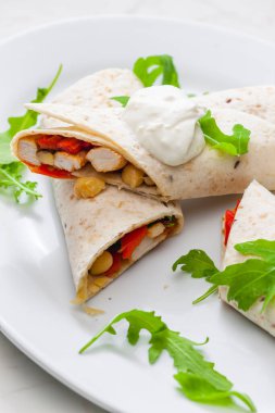 Tavuk eti, kırmızı biber ve fasulye dolu tortilla.