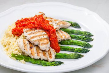 Kızarmış tavuk eti, fırında kırmızı biber sosu ve yeşil kuşkonmaz.