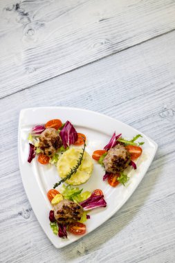 İnce kıymalı biftek, patates püresi ve salata.