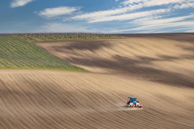 İlkbahar başlarında tohum matkabıyla traktör.