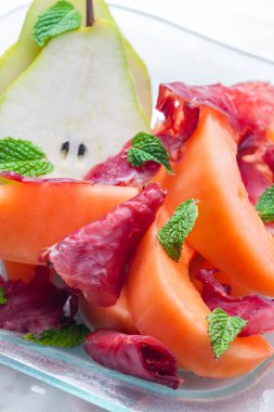 kavun kavunu ve armut, proscutto ve nane yapraklı.