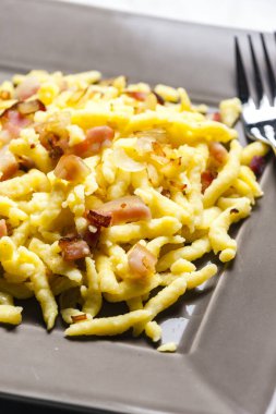 Kızarmış domuz pastırması ve soğanlı spaetzle.