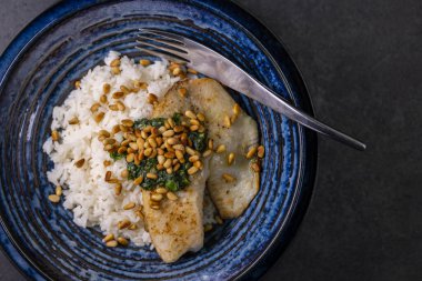 Ev yapımı fesleğen soslu beyaz morina balığı ve kavrulmuş çam çekirdeği.