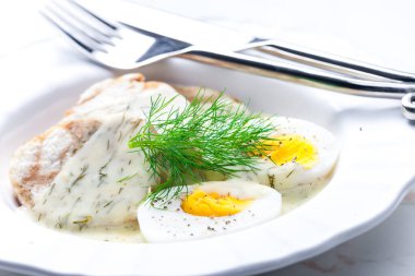 Hamur köftesi ve haşlanmış yumurta ile dereotu sosu.