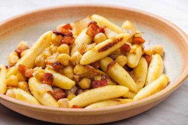 Domuz pastırmalı, soğanlı ve bezelyeli schupfnudel.