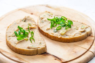 Çıtırtılar taze soğanla ekmeğe yayılıyor.